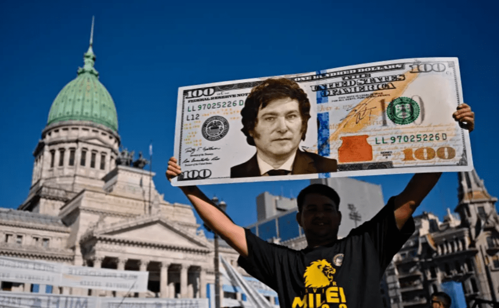 supporter of Argentina's Javier Milei displays a $100 bill placard with an image of the president